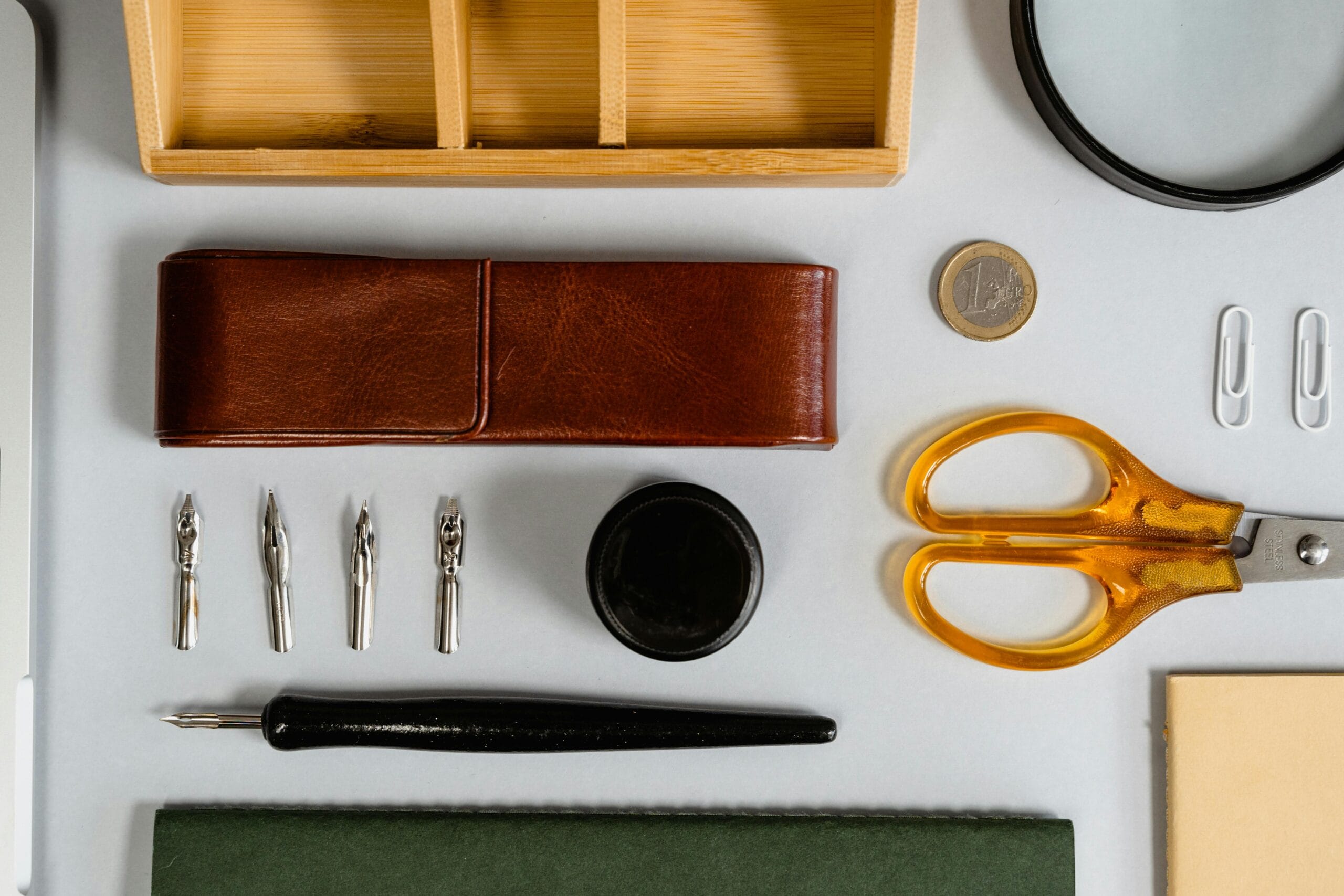 Top view of writing tools, office supplies, and stationery arranged on a flat surface.