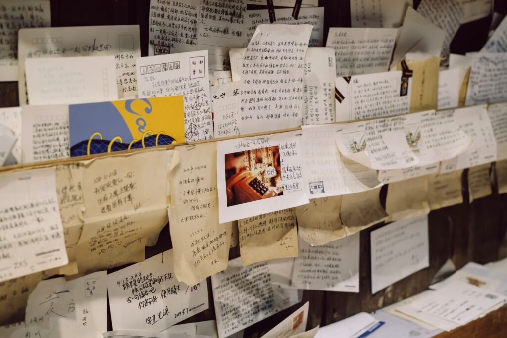 Close-up of a wall densely covered with various handwritten notes and letters.